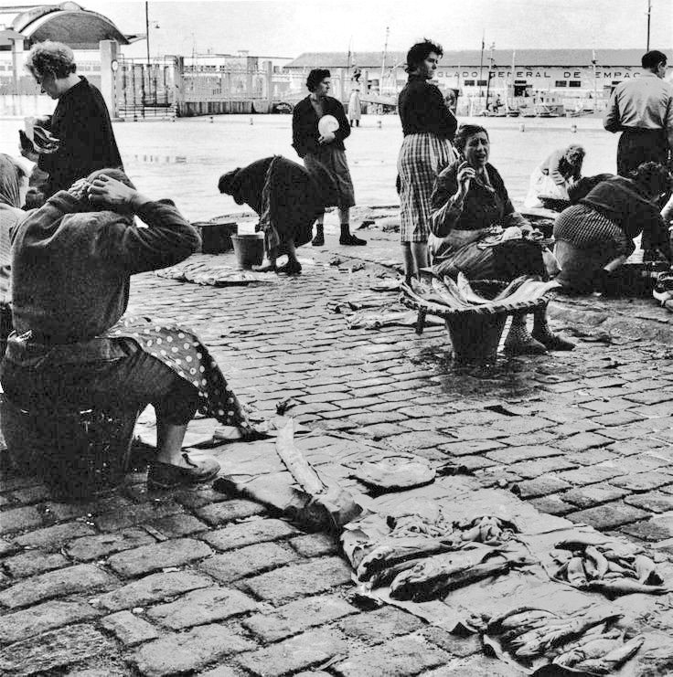 Mulleres traballando na ribeira do Berbés, Vigo.
📷 Jean Dieuzaide, 1961.
Unha imaxe que temos gravada as persoas que vivimos nesta cidade é a do rótulo do porto "TINGLADO GENERAL DE EMPAQUE": Unha frase que liamos dende o asento do Vitrasa ao seu paso polo Paseo de Alfonso.