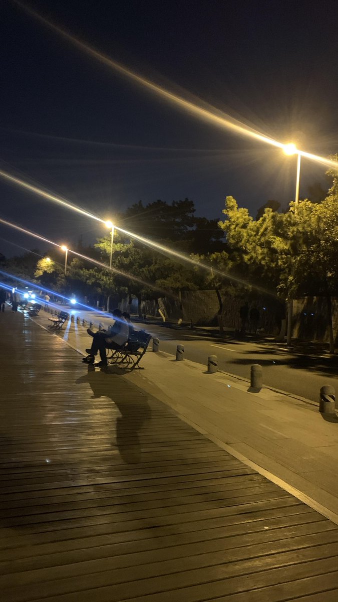 On the streets at night, the breeze blows gently, and the figures under the lights speak of tranquility and thought.