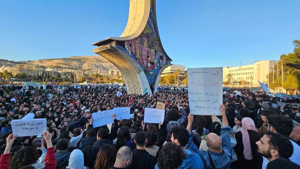KareemRifai's tweet photo. A peaceful demonstration today of Muslims and Christians together in the heart of Damascus, calling for a secular, democratic Syria.

The woman's sign reads: "there is no free society without free women."

Under Assad, this type of assembly was banned and violently put down. https://t.co/dNWh7u4lpP