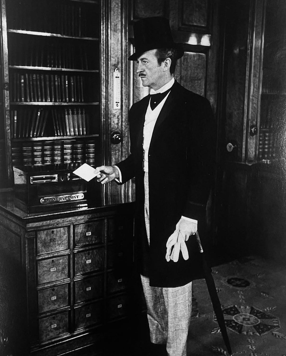 JuanmadelaPoza's tweet photo. #DavidNiven, como el taciturno, misterioso y rico caballero londinense #PhileasFogg en el #ReformClub, un tradicional club privado inglés de caballeros en Pall Mall, durante el rodaje de #LaVueltaAlMundoEnOchentaDías (#AroundTheWorldInEightyDays, 1956), de #MichaelAnderson. Una película de aventuras muy entretenida que adapta la novela homónima de #JulioVerne, donde un ladrón ha robado 55 000 libras del banco de Inglaterra. Todos creen que ha sido Phileas Fogg, un auténtico caballero inglés, que ha hecho una apuesta con sus compañeros de club, asegurando que es capaz de dar la vuelta al mundo en ochenta días. Próximo viernes 20 de diciembre de 2024 en #Classics. A las 22:00 en @TRECE_es. Sin ser una obra maestra, «La vuelta al mundo en ochenta días» es una de las cimas dentro del género de aventuras y entretenimiento. La película lo tiene todo: acción, drama, wéstern, cine negro, musical... Entretenimiento puro, de principio a fin, en el que destacaría los cameos que van apareciendo en la pantalla mientras los dos protagonistas de la película, el impecable David Niven y un divertido #Cantinflas (en su debut en el cine estadounidense), dan la vuelta al mundo. Un espectáculo total, que les devuelve a los espectadores la auténtica magia del #Cine. Aunque en el momento de su estreno, en la mayor parte de los países donde se estrenó, se proyectó en Cinemascope, tuve el privilegio de verla en una función privada en el sistema en el que se rodó originalmente: Todd-AO, un formato de película de pantalla ancha creado por #MichaelTodd, el productor de «La vuelta al mundo en ochenta días». La película se estrenó en los cines el 17 de octubre de 1956. Con un presupuesto de unos 6 000 000 dólares, la película recaudó, aproximadamente, 33 000 000 dólares en el momento de la muerte del productor. El 27 de marzo de 1957, en la 29.ª edición de los Premios Óscar, «La vuelta al mundo en ochenta días» ganó el #PremioÓscar a la mejor película.