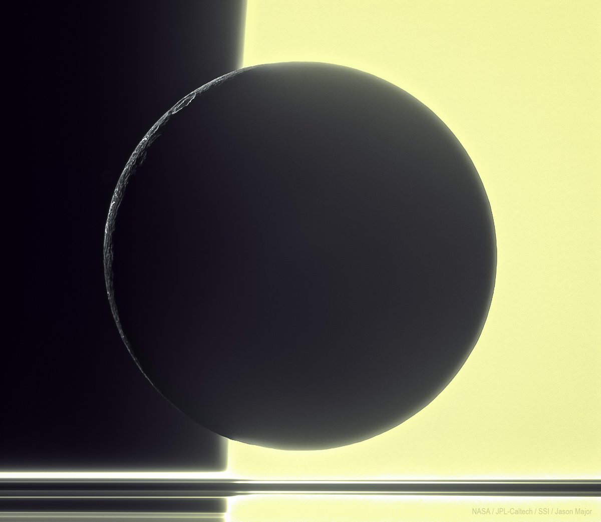 This is the silhouette of 1,122-km-wide Dione in front of Saturn: a view captured with Cassini 14 years ago on December 20, 2010. Synthesized color from a single clear-filter greyscale image.