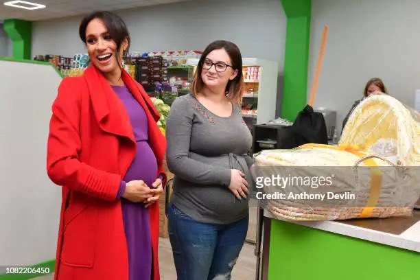 MeghansMole's tweet photo. Shall we compare Meghan Markle’s prosthetic belly to the woman who is actually pregnant next to her  

Notice how the woman in grey doesn’t need to hold up her belly like Meghan does 

🤭🤭 https://t.co/1z58Pi9bdv