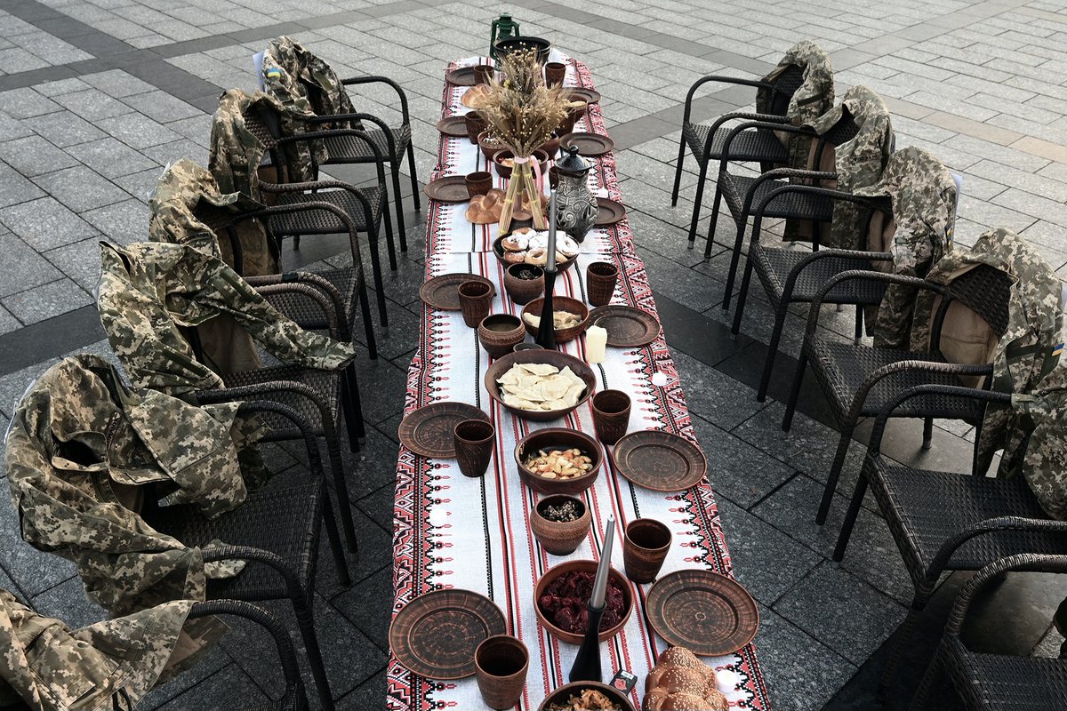 YurkoDyachyshyn's tweet photo. Soldiers’ uniforms hang on empty chairs next to a symbolic Christmas table set with traditional dishes as people attend a rally in reminder of prisoners of war and missing Ukrainian soldiers in Lviv on December 21, 2024.
📷Yurko Dyachyshyn https://t.co/umFIrYulu2