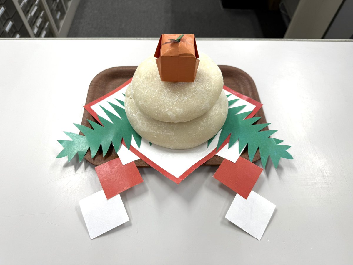 sandarunosuke's tweet image. 会社のカウンターにおもちが出現したので、台と飾りを足していました。
かわいい橙(だいだい)を作ってのせてくださった方がいらして、天才かと思いました。
鏡餅感がグンとアップ！