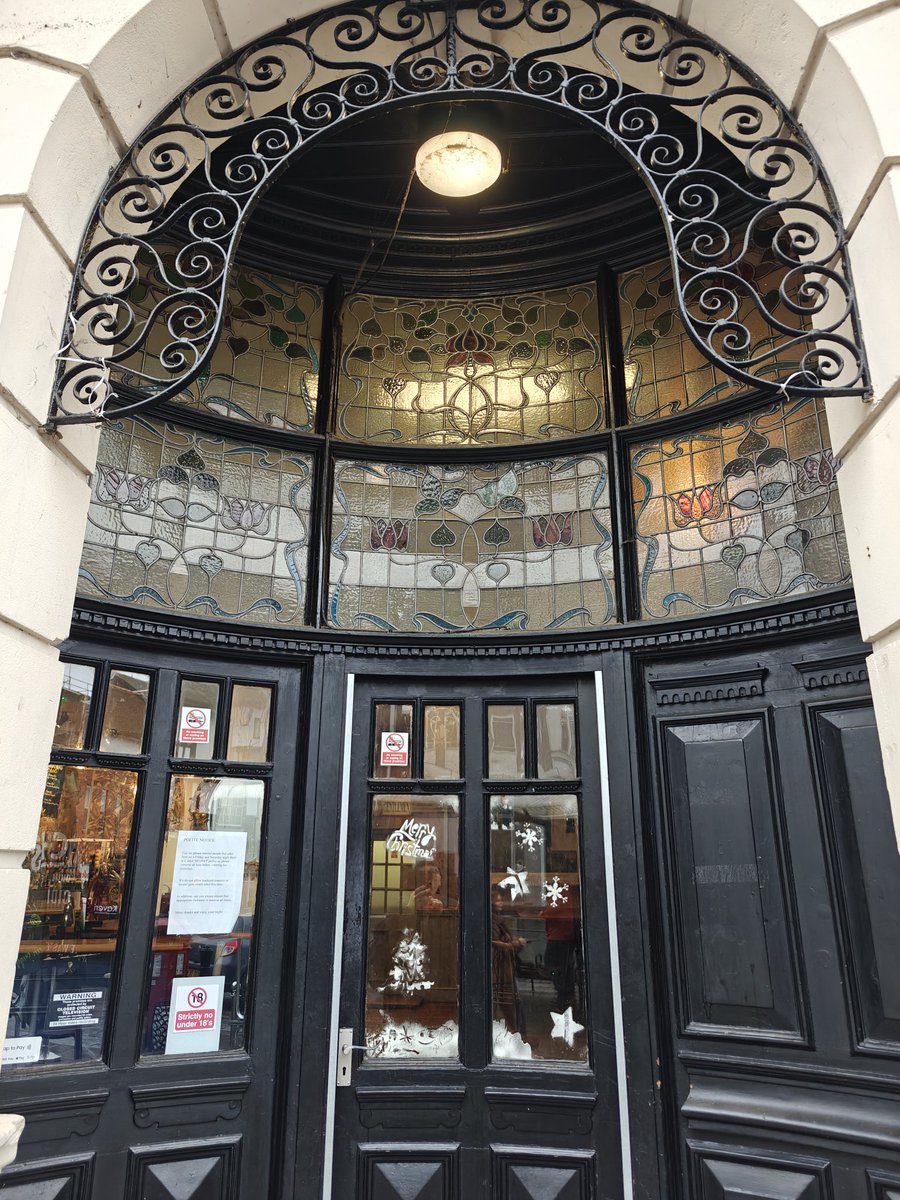 ColCivicSociety's tweet photo. You'll find this six panel, curved stained glass #AdventWindow  over the door of the After Office Hours pub/cocktail bar (originally The  Lamb and later the Bay &amp; Say and Faunus &amp; Firkin) on #Colchester High Street.

The building is Grade ll listed.

More:
https://t.co/p70GGgoifl https://t.co/U9qN63c18M