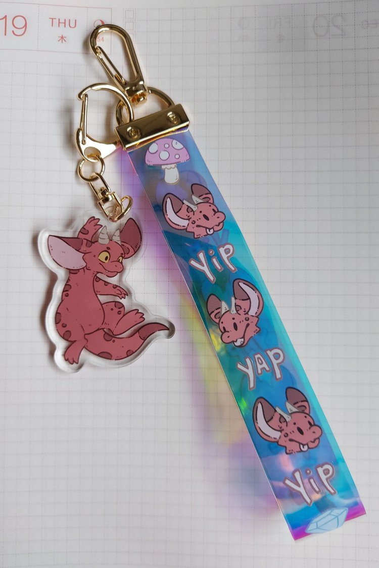 Would you like to add some kobold shenanigans to your life?   

Perhaps this kobold holographic pvc lanyard that comes kobold acrylic charm with a can help you with that! 

You can find the pre-0rders on our site until the end of the 24th.