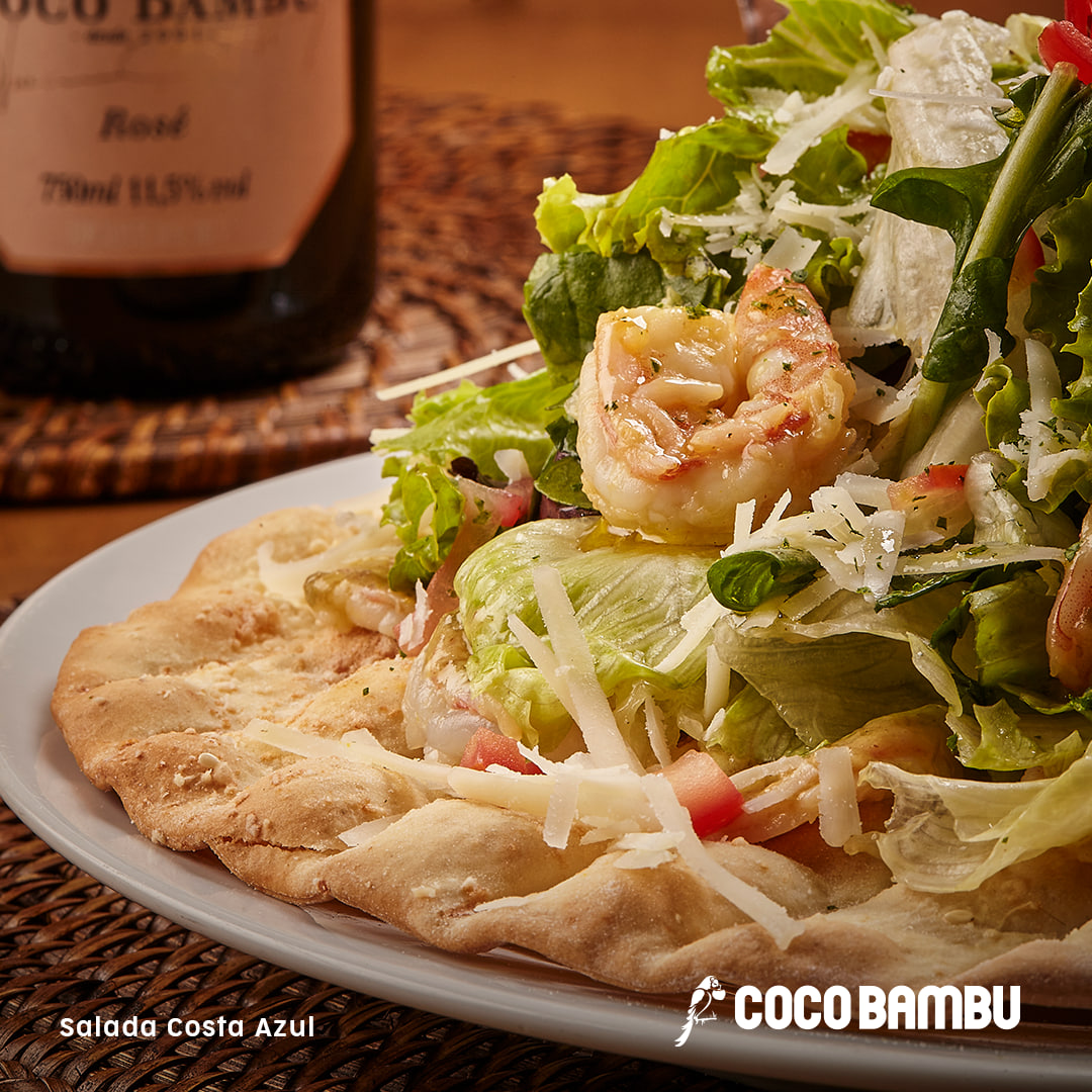 CocoBambuReal's tweet photo. A Salada Costa Azul chegou para trazer frescor e sabor ao seu dia! 🥗💙
Mix de folhas verdes com lâminas de camarão marinado no pesto de alcaparra e parmesão cobertos com camarões salteados. Servida na casquinha de pizza.
Vem experimentar! 🍤
#CocoBambu #AppCocoBambu #Salada #Leve
