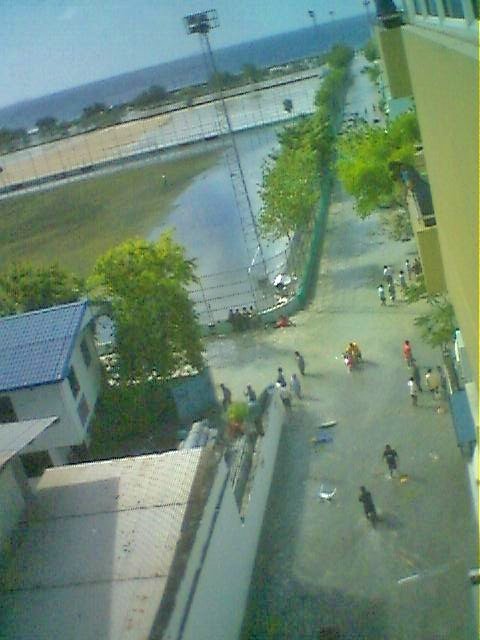 Ludges's tweet image. I took pics of sea encroaching on Malé just as 1st wave of 2004 Asian Tsunami reached Maldives. The more potent 2nd wave initially pulled back lagoons dry to reveal coral reefs as walls for those standing on the beach before it too swept as a treetop high wall  across the country