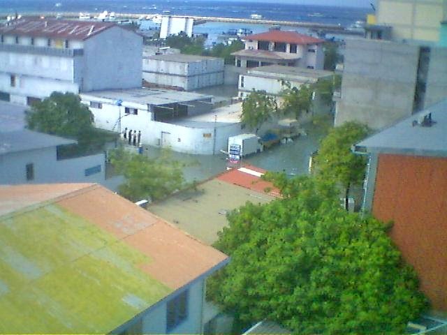 Ludges's tweet image. I took pics of sea encroaching on Malé just as 1st wave of 2004 Asian Tsunami reached Maldives. The more potent 2nd wave initially pulled back lagoons dry to reveal coral reefs as walls for those standing on the beach before it too swept as a treetop high wall  across the country