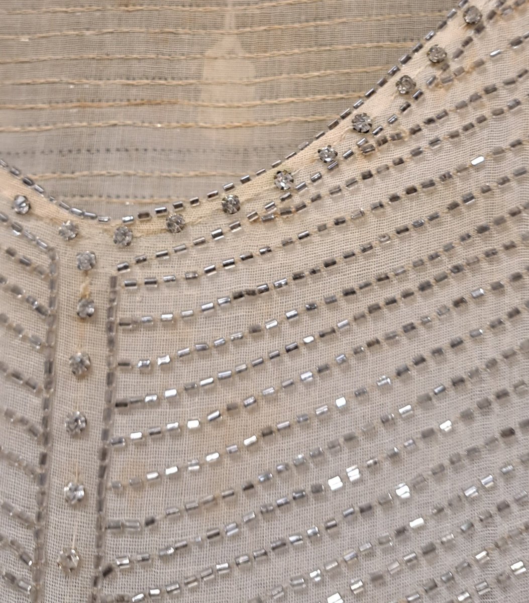 PrincessHamira's tweet photo. A glimpse at the beadwork on an imported French evening dress, look at the reverse to see how the heavy glass beads are secured. It was skilled work and  beautiful in its time. #1920s #Unflappable #Killerton 2025 #1920sfashion https://t.co/mNsHoejiJa