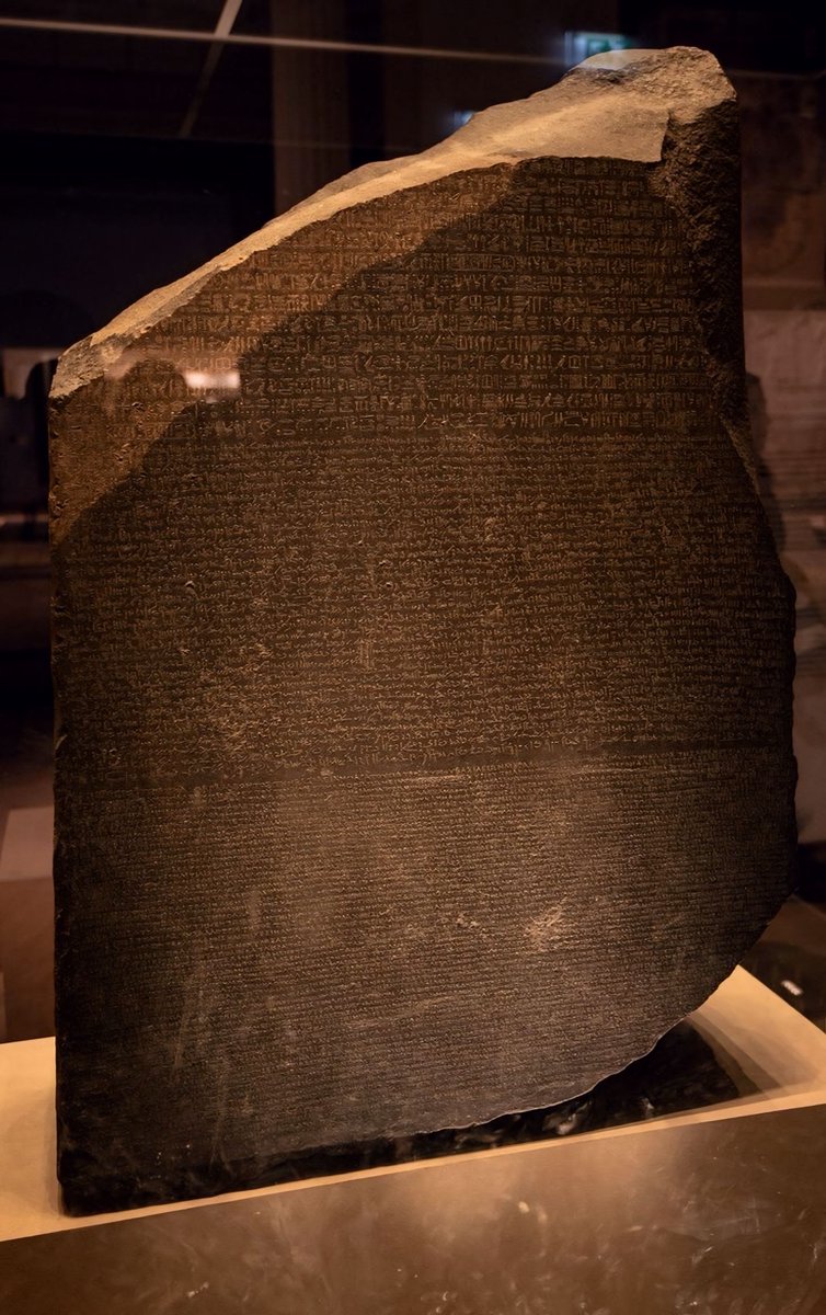 The Rosetta Stone, unearthed in 1799, played a crucial role in the interpretation of Egyptian hieroglyphs due to its inscription of the same text in three different scripts: Greek, Demotic, and Hieroglyphic.