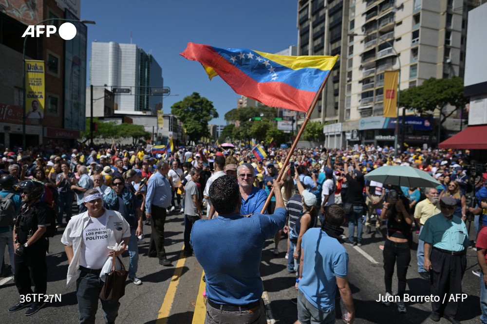 A demonstrator waves a Venezuelan flag during a protest called by the opposition on the eve of the presidential inauguration in Caracas on January 9, 2025