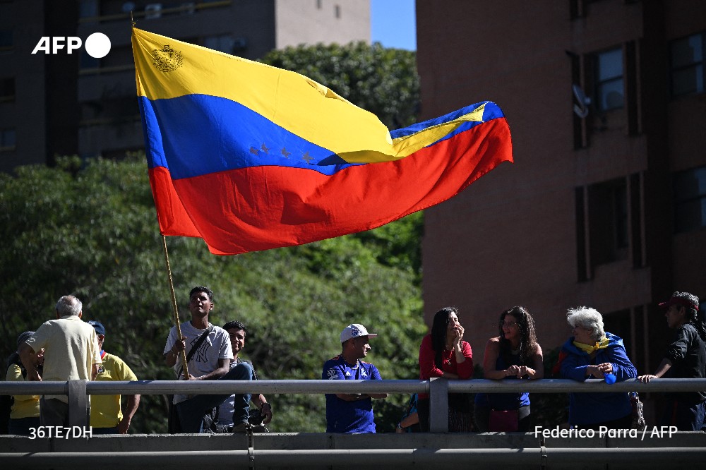 A man waves a Venezuelan flag during a protest called by the opposition on the eve of the presidential inauguration, in Caracas on January 9, 2025