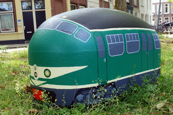 In de Oosterstraat, achter het spoorwegmuseum, liggen betonnen 'varkensruggen' in het gras om te voorkomen dat er wild geparkeerd wordt door bezoekers. Deze zijn beschilderd als treinstellen 🤓 #treinnerdtweet