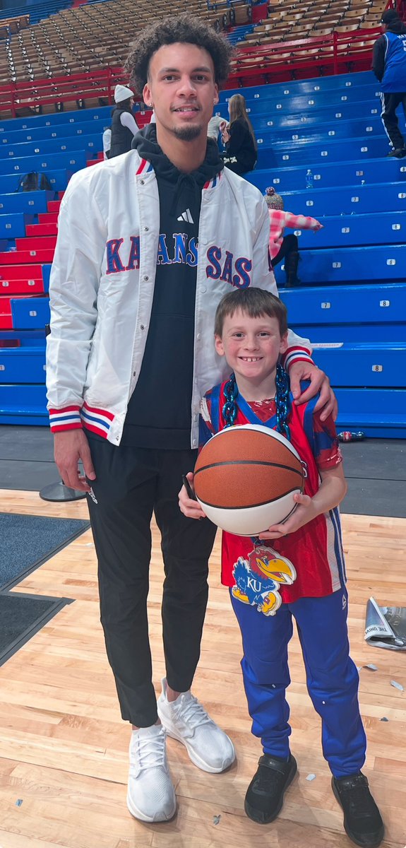 BHanni's tweet photo. It always fills me with great pride to watch our student-athletes impact others from their platform and last night I got a special glimpse of that from @zekexmayo.

I had a pleasure of giving a postgame tour to our #KUCancerFighter family of the day, the Jowler Family of Inman, KS. Korbyn is one of 3 kids whose sweet Mom, Ashley, is battling cancer. Korbyn accompanied his parents on the tour and got to meet one his heroes, Zeke Mayo.

Knowing that Korbyn wants to follow in Zeke’s footsteps as a Kansas kid who one day plays for the Jayhawks, I asked Zeke to share some wisdom on what it might take fulfill such a dream. To be fair, I gave Zeke zero advance notice and truly put him on the spot with the question but he handled it like such a pro.

Zeke got down and looked Korbyn squarely in the eyes and said, “Always remember that where you start doesn’t have to be where you finish. You can come from a small town or far away place and still finish where you dream, so long as you’re willing to put in the work. I’m not just talking about work on the court, either. In order to be the best basketball player you can be, it starts with being the best son and big brother you can be. Always listen to your parents, strive to set a good example, work hard in school and try to get better each day with that same end goal in mind. Do all that and you can absolutely live that dream.”

Korbyn hung on each & every word. His parents and I were all speechless too. Tremendous advice from the young man who just hung 23 on the Sun Devils, and then provided some life-changing motivation & inspiration to one of the youngest fans in attendance (not to mention, a great diversion from the cancer battle for Korbyn’s mother).

Good for you, Zeke. Your 5 threes last night had us all on our feet, but your inspiring words after made many Mayo fans for life. Rock Chalk! #kubball