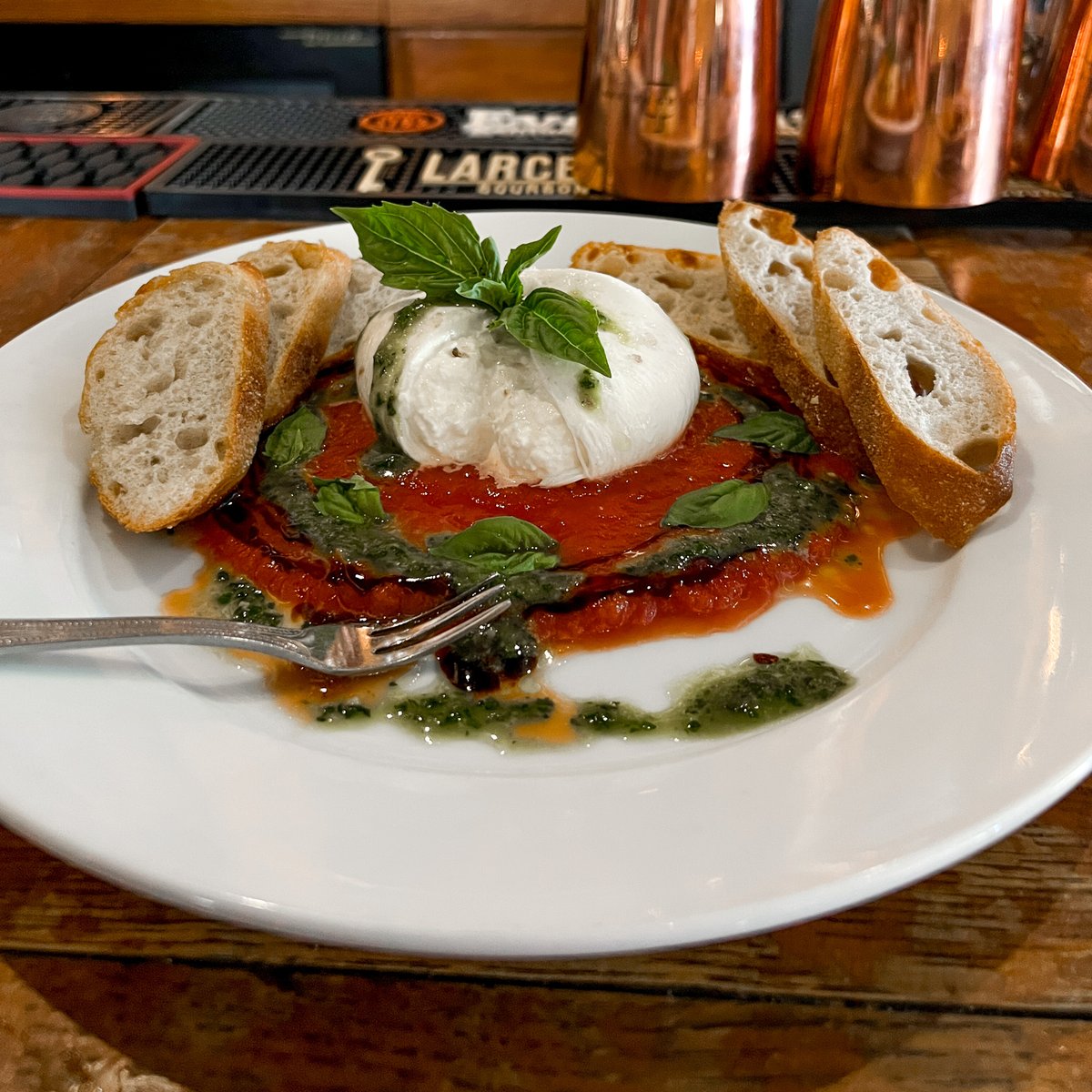 Our Burrata starter is a dreamy blend of creamy Italian mozzarella, San Marzano tomato sauce, basil pesto, balsamic glaze, an Maldon smoked sea salt. Order it for the table or for yourself! #bourbonsbistro