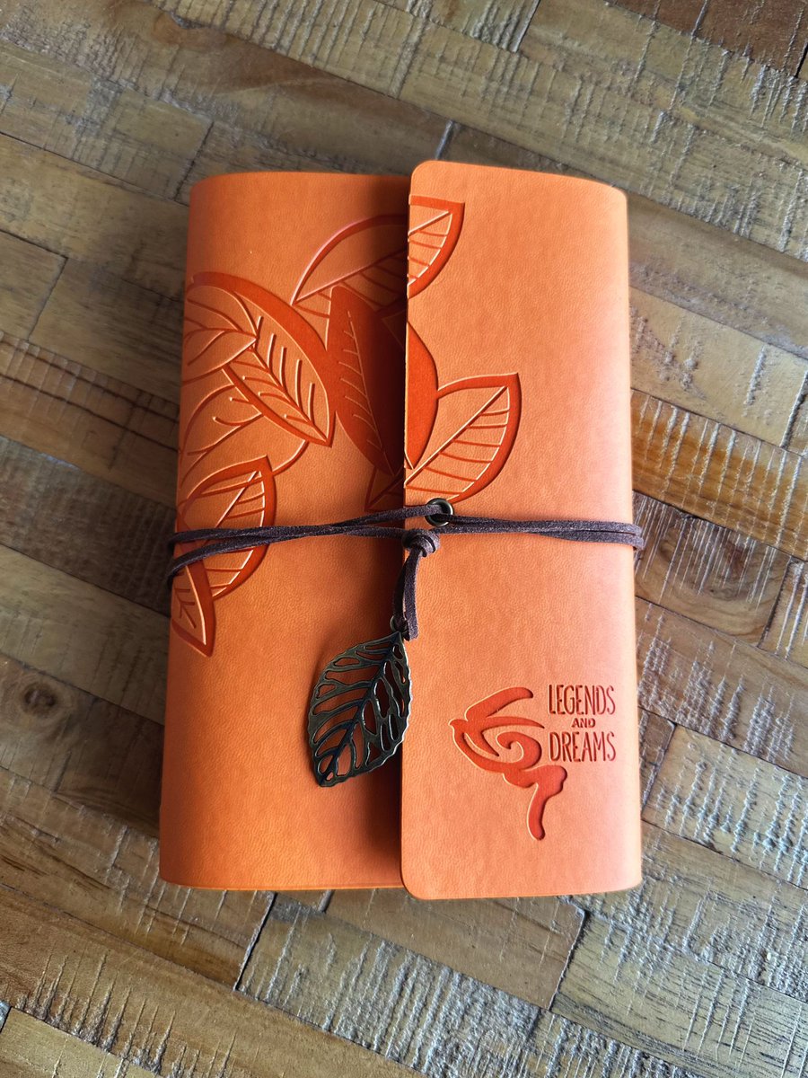 Legends &amp; Dreams Journal Travel Notebook - Orange 
Introducing the Legends &amp; Dreams Traveler's Journal – a beautifully crafted notebook that blends elegance with functionality, perfect for note-takers, writers, travelers, and dreamers alike. The journal is wrapped in a soft, i...