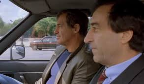 merlinpapin3's tweet photo. .@FredOL69007 #DéfiCinéClassique2025 (Disparu en 2024 – #PierreVernier) avec le film #LeMarginal de Jacques Deray (1983) avec Jean Paul Belmondo Carlos Sotto Mayor Henri Sylva Maurice Barrier Pierre Vernier Tcheky Karyo Claude Brosset Jean Claude Dreyfus Jean Louis Richard Michel Robin
Le commissaire Philippe Jordan (Jean-Paul Belmondo) est un flic aux méthodes expéditives. Encombrant tant pour ses supérieurs que pour ceux qu'il traque, en raison de méthodes souvent peu licites, il ne manque pas d'efficacité. Récemment muté à Marseille, il veut mettre hors d'état de nuire Sauveur Mecacci, un des parrains de la French Connection et pédophile notoire, pour qui Jordan éprouve de la rancœur.
Après une poursuite en hélicoptère, duquel il saute sur un bateau, il saisit deux cents kilos d'héroïne qu'il jette à la mer. Jordan est cependant saqué à la suite de la découverte du cadavre d'un indicateur dans son salon pour le faire tomber. Jordan se retrouve alors dans un commissariat de police parisien, un « placard à balais », où il fait équipe avec l'inspecteur Rojinski, l'un de ses amis dans le commissariat.
Le Marginal (1983), réalisé par Jacques Deray et porté par Jean-Paul Belmondo, est une œuvre qui, malgré son succès populaire, peine à se hisser parmi les meilleures collaborations du duo Deray-Belmondo. Le film suit les aventures du commissaire Jordan, un flic aux méthodes musclées, en quête de justice dans un monde gangréné par le crime. Si la formule semblait prometteuse, elle souffre d'un essoufflement certain, avec un scénario qui recycle des situations vues dans des œuvres précédentes du duo, notamment Borsalino
Belmondo, bien que charismatique, semble ici moins incisif, presque en pilote automatique, comme s’il se contentait de son statut d’icône du cinéma populaire des années 80. Les cascades, autrefois un atout majeur de ses films, manquent d’audace, et son personnage manque de profondeur. La présence de Henry Silva, en méchant redoutable, vient heureusement redonner un peu de mordant à l'intrigue. Fidèle au poste, Pierre Vernier, récemment disparu en 2024, incarne avec sa subtilité habituelle un adjoint solide, bien que sous-exploité.
Cependant, un des aspects les plus regrettables reste le peu de mise en valeur des dialogues signés Michel Audiard. Ces répliques acérées, qui sont souvent un régal, paraissent ici noyées dans une mise en scène fonctionnelle mais sans éclat. La direction artistique, bien qu’efficace pour capturer les bas-fonds de Marseille et Paris, manque d’une véritable signature qui aurait pu élever le film.
En résumé, Le Marginal reste une œuvre divertissante mais prévisible, souffrant d’un manque de renouveau et d’ambition. Si l'on salue la présence de Silva et Vernier, et quelques scènes mémorables, l'ensemble manque d'énergie pour figurer parmi les classiques du cinéma français.