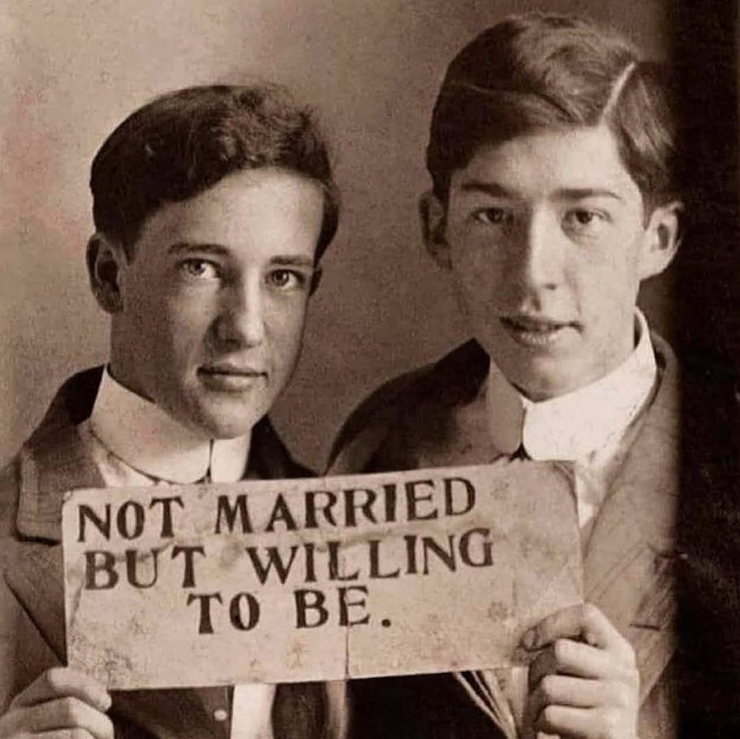 HistoryInPics's tweet image. Two young men hold a sign proclaiming their love and willingness to be legally married to one another, circa 1900.