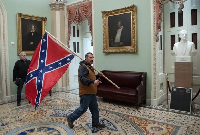 According to MAGA, carrying a Confederate flag into the rotunda is “patriotic”, but lowering our flags to honor the passing of a former President, is not.