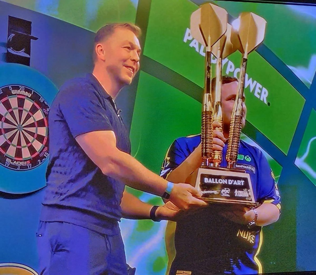 Sir Chris Hoy presenting Luke Littler with a trophy made from Gary Barlow's son's darts 😅