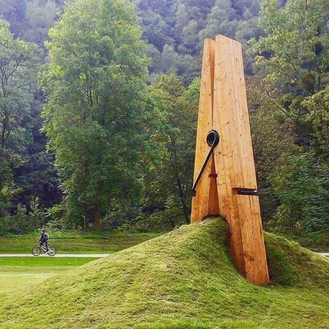 Rainmaker1973's tweet photo. Designed by Turkish artist Mehmet Ali Uysal, this giant clothespin sculpture that seems to be holding onto a mound of dirt and grass, resides on the outskirts of Liege, Belgium. https://t.co/rfHXRBW2Jz
