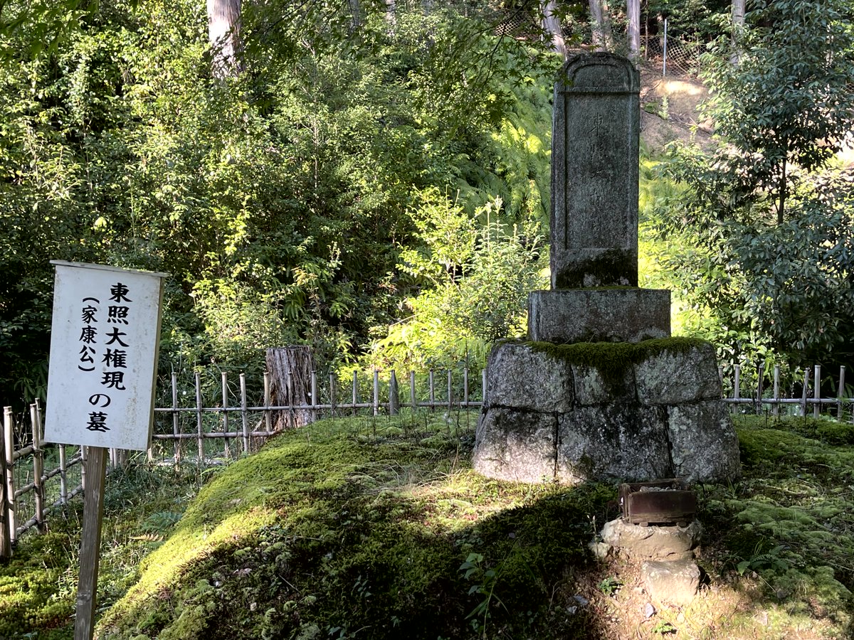 Hiroporin's tweet photo. 緑豊かな森の中、苔むした古い墓石が佇む。「東照大権現（家康公）の墓」と書かれた看板が、この場所の歴史的重要性を物語る。自然と歴史が融合した静寂な空間に、時が止まったかのような趣が漂う。#歴史 #徳川家康 #日本の文化 https://t.co/RQcDdGr45z