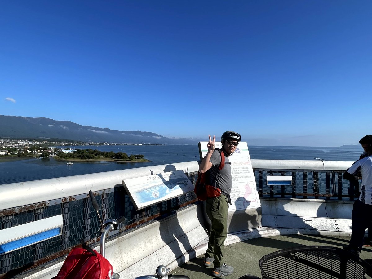 Hiroporin's tweet photo. 美しい海と山々を望む絶景ポイントにて。青空の下、サイクリングを楽しむ人の姿も。地元の魅力を再発見できる贅沢な一日。自然と都市が調和する風景に心奪われる瞬間。#絶景 #サイクリング #旅の思い出 https://t.co/7m93vfsPFh