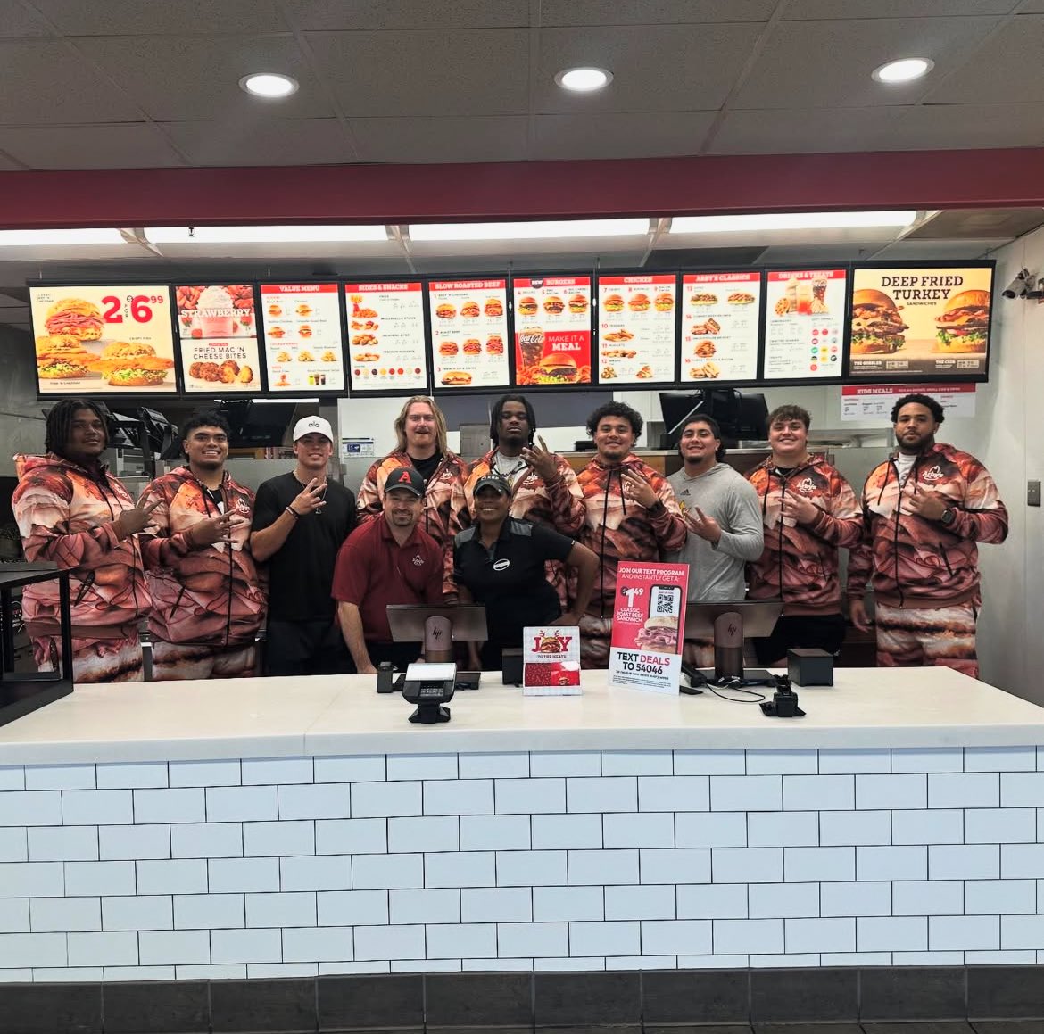 Blakes_Take2's tweet photo. Sam Leavitt, who helped orchestrate a NIL deal between Arby’s and eight of ASU’s offensive linemen, poses for a photo with Josh Atkins, Leif Fautanu, Emmit Bohle, Max Iheanachor, Sean Na’a, Makua Pule, Cade Briggs and Ben Coleman at the establishment. 

Peep the meat suits. https://t.co/nfeg8TRal5