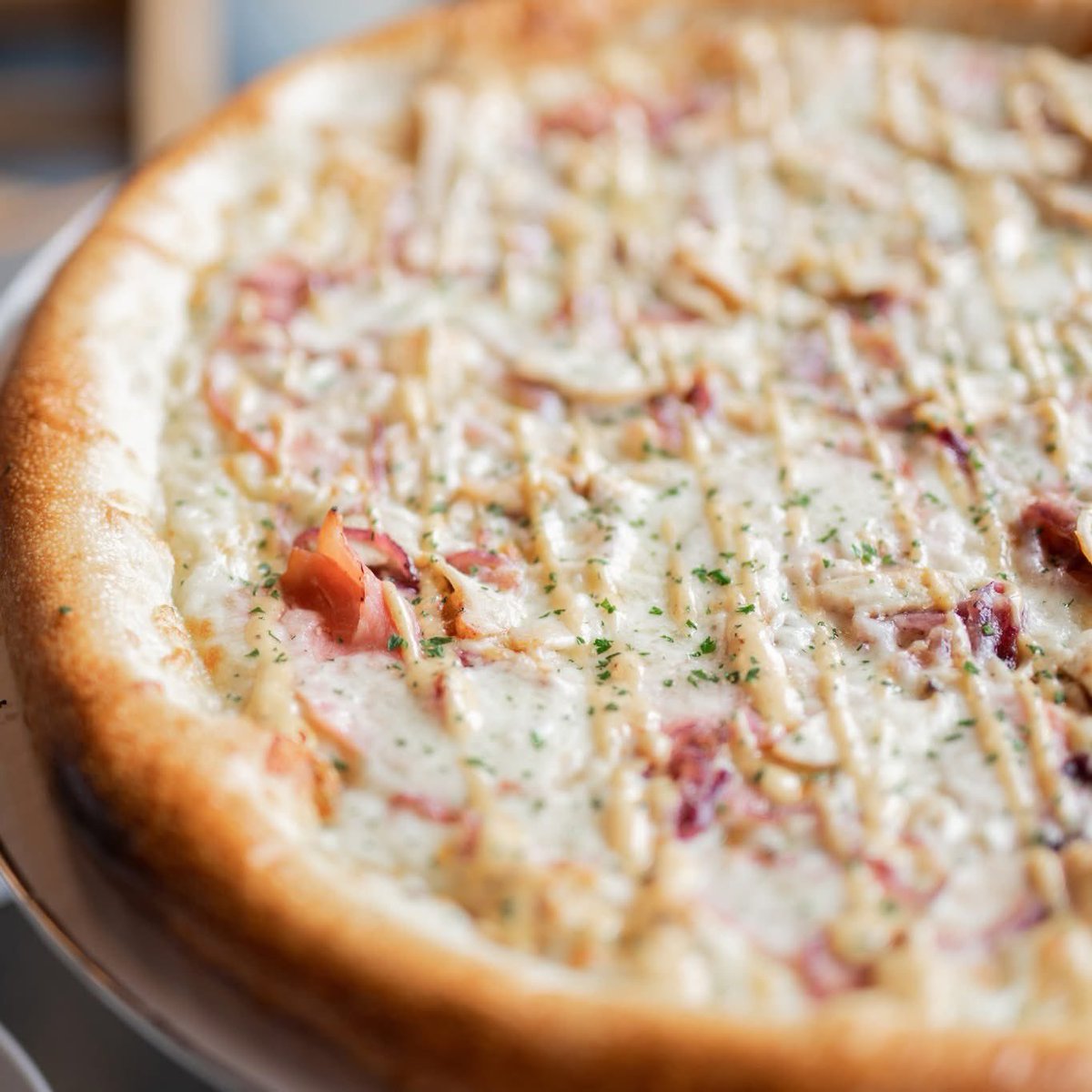 First place flavor. 🥇 The Bleu Ribbon features olive oil, mozzarella provolone, smoked ham, Amish chicken, brown caramelized sugar onions with parsley and our homemade roasted garlic aioli after the bake. Try it today at deweyspizza.com