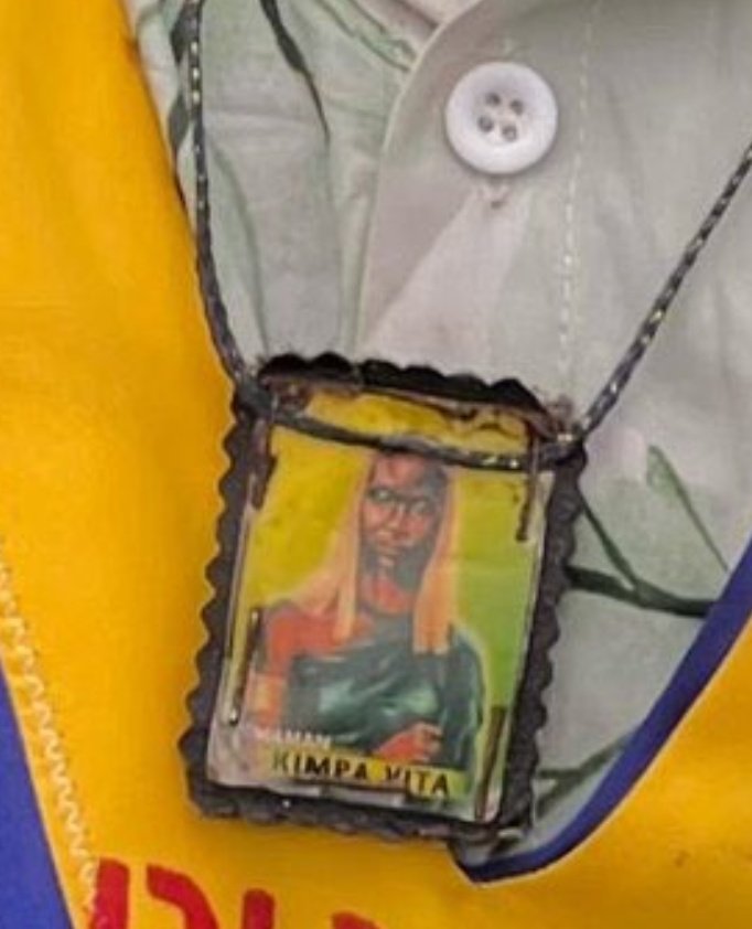 Observateur_X's tweet photo. Il avait un pendentif de Kimpa Vita autour du cou. Je me demande ce qu'il savait de Kimpa Vita et pourquoi il portait ce pendentif.

Derrière chaque personne, il y a une histoire cachée. Nous ignorons ce qui lui est arrivé afin qu'il devienne Kuluna, mais je suis sûr et certain qu'il avait une connaissance qui lui permettait de garder Kimpa Vita en mémoire.
