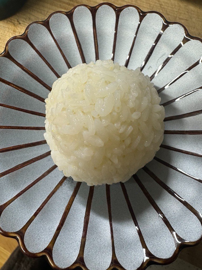 RAKUGOUKAI001's tweet photo. 新しい年を迎え、絡合会では理事、相談役、そして用務員の皆様からいただいた年始のご挨拶と自己紹介文を順次公開いたします。

《絡合会秋田県用務員さんより》

明けましておめでとうございます。秋田の用務員を務めさせていただきます岡田友紀子と申します。

今年はオーガニック給食を進める活動や秋田の自然を守る活動、不登校の子も大人も集える居場所づくりを地域の先輩・仲間と取り組んでいきます。私には幼稚園と小学生の子がおり、お母さんを一番にしながら次世代の為に頑張りたいと思っています。

昨年絡合会と出会い、理念に心から共感し希望を感じています。自己の絡合力を鍛え実践し、秋田の入会希望・会員の方と積極的に楽しい交流を重ね、会に貢献したいと思っております。どうぞよろしくお願いいたします。

（写真は、子が昨年末に初めて握って私にくれたおにぎり、自然栽培のあきたこまち、地元の源流近くの川で遊ぶ様子です）