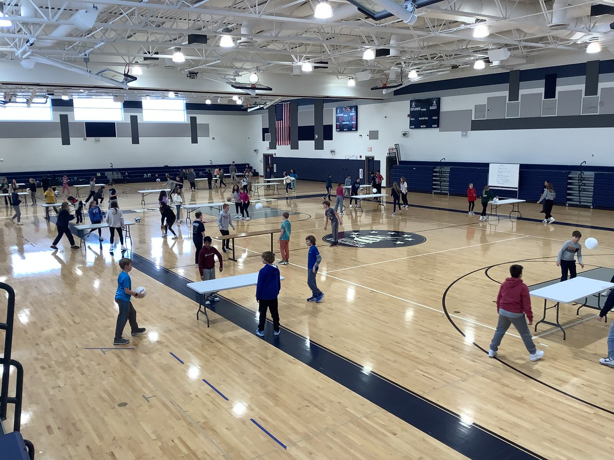 The 6th-grade PE class is participating in a lead-up game called "table ball," which aligns with their upcoming volleyball unit. The skills developed through this non-traditional game will effectively transfer. Ss are enjoying themselves while fostering teamwork and coordination