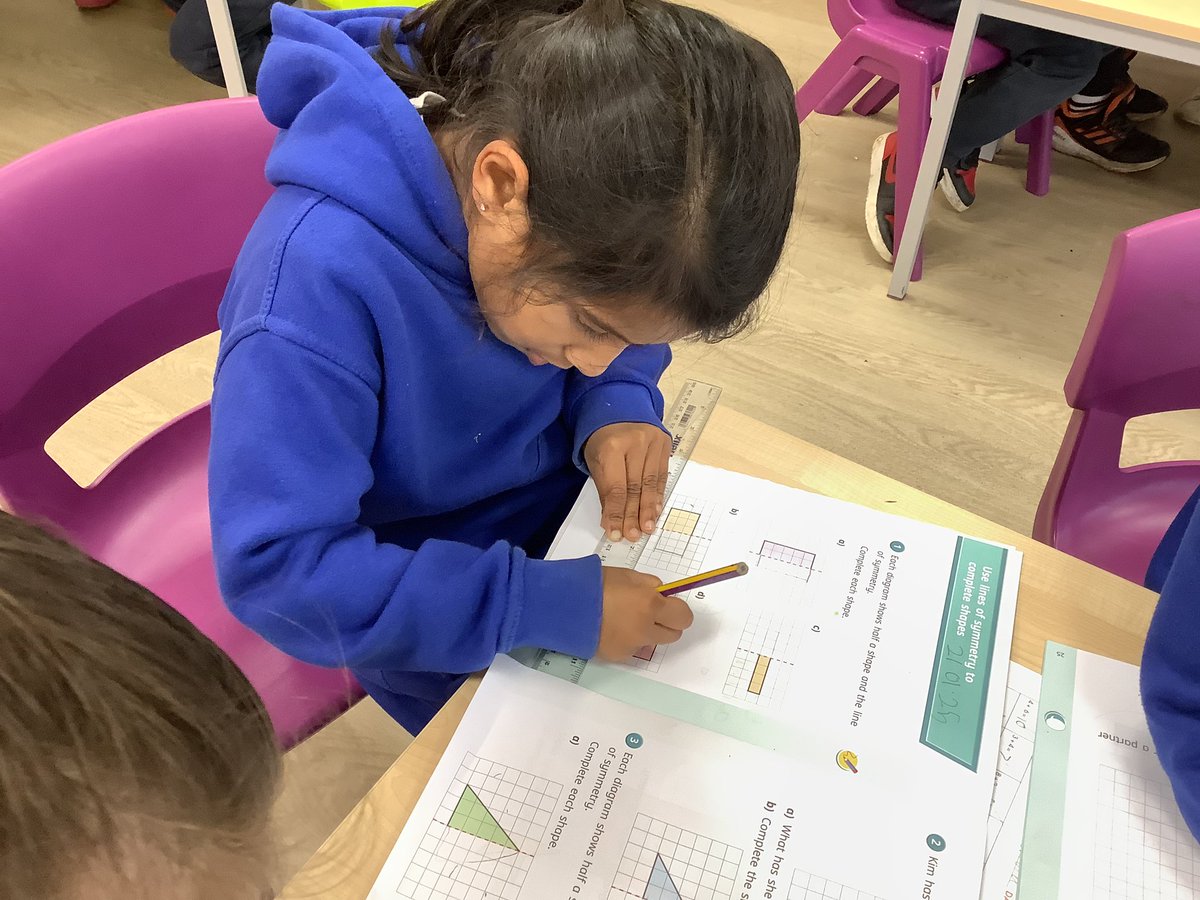 Year 2 are getting to grips with rulers to draw 2D shapes in a vertical line of symmetry!