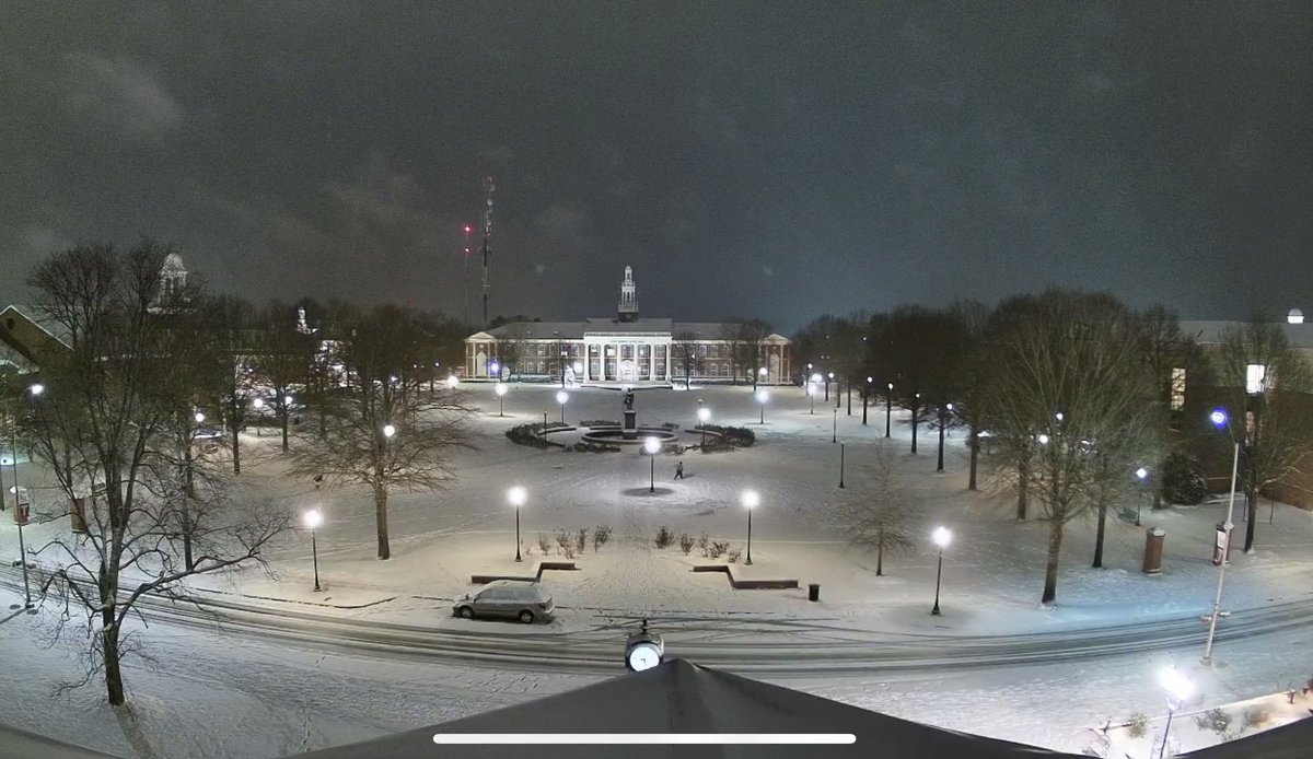 Main quad as night falls on snow day at Troy University.