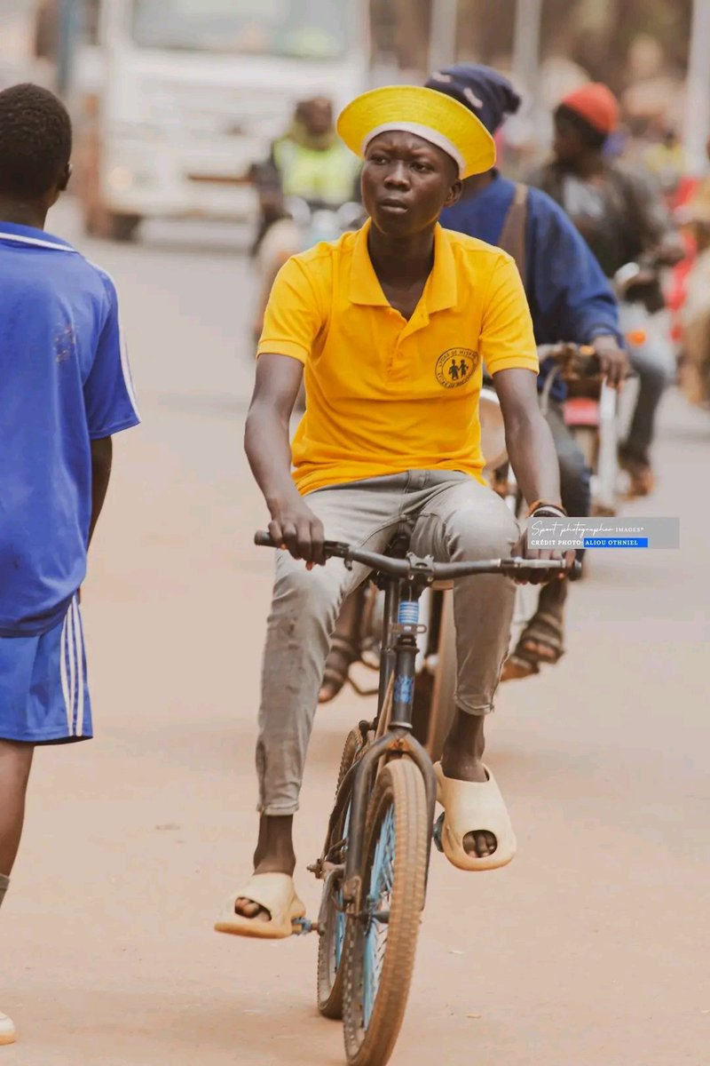 Un élève qui fait du vélo dans les rues de Bangui.
