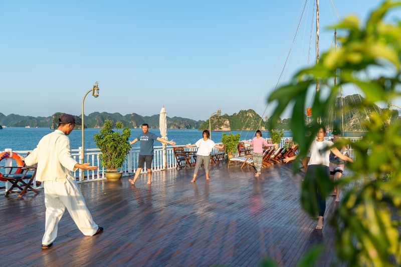IndochinaSails's tweet photo. Let the gentle movements of Tai Chi guide you into a state of calm and balance, surrounded by the breathtaking beauty of Vietnam's most iconic heritage site. This peaceful activity on the open waters offers the perfect start to your day, bringing harmony between mind and body. https://t.co/ITRVcxvQVx
