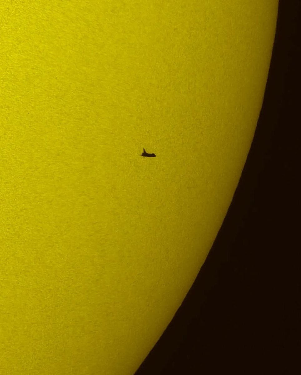 Space Shuttle Atlantis silhouetted against the Sun