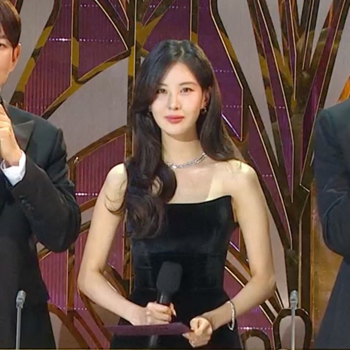 SeohyunPoint's tweet photo. Seohyun looks like royalty and her soothing voice is the prettiest to listen to. Of course the atmosphere is solemn to respect the mourning and she's standing for a long time without her cane so it isn't an easy night but she's calm and professional as always. Best MC 🖤 https://t.co/26UfbJzvxz