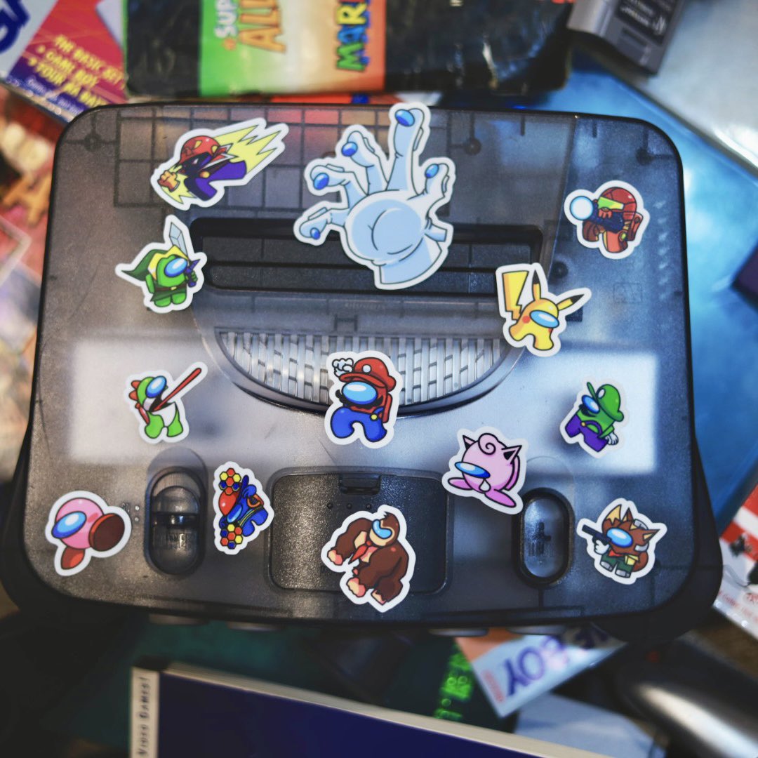 LegendsCookbook's tweet photo. ඞ Super Amogus Bros: The Sticker Sheet No One Asked For (But You’re Getting Anyway) ඞ  

Fanmade and horribly unofficial. It’s 2025, and yes, I made an Among Us x Super Smash Bros. N64-inspired sticker sheet. Dead meme? Absolutely. Nostalgic crossover? Not really. But it came to me in a dream, and who am I to ignore divine inspiration?  

These 13 stickers are a love letter to bad ideas, outdated references, and my inability to let things go. Call it art, call it cringe—I call it destiny.  

Sticker Roster Highlights:  
- Sussy Kong: Tossing barrels and venting. Pure chaos.  
- Kirbo: Big, pink, and ready to inhale your tasks.  
- Captain Suscon: Screaming “Show me your moves!” while sabotaging electrical.  
- Yellowchu: Pikachu, but sus. Honestly, I regret this one.  
- Mario-but-sus: Definitely faking tasks and leading Emergency Meetings.  
...and six more icons that blend sus energy with pixelated nostalgia.  

Why did I make this?  
Because I could. Because it’s funny. Because nobody stopped me.  

Important Details:  
- Title: Super Amogus Bros. Sticker Sheet  
- Size: 9"x4" sheet with 13 stickers (avg. size 1.5"x1.5")  
- Finish: Satin (perfect for your venting aesthetic)  
- Limited Run: Only 50 sheets, because even I have limits.  
- Artist: @ZachJaDa (blame them).  

Shipping:  
- Ready to ship now (expect international to take longer, because suspense is fun).  
- Shipped in a basic envelope because I’m cheap.  
- No replacements if lost—this joke is one of a kind.  

Get yours now and own a piece of meme history. Or don’t. Either way, I win.  

Link in bio!  

#DeadMeme