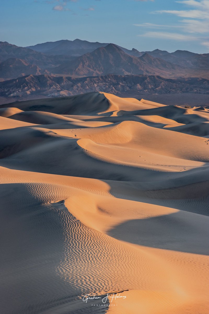 GrahamHolmesDP's tweet photo. Golden light spills across the Mesquite Flat Sand Dunes at sunrise, highlighting delicate textures and shadowed curves. Death Valley’s beauty is truly humbling in the quiet morning stillness. 🌄 #DeathValley #MesquiteDunes #SunrisePhotography #LandscapePhotography https://t.co/ggQdeTEErL