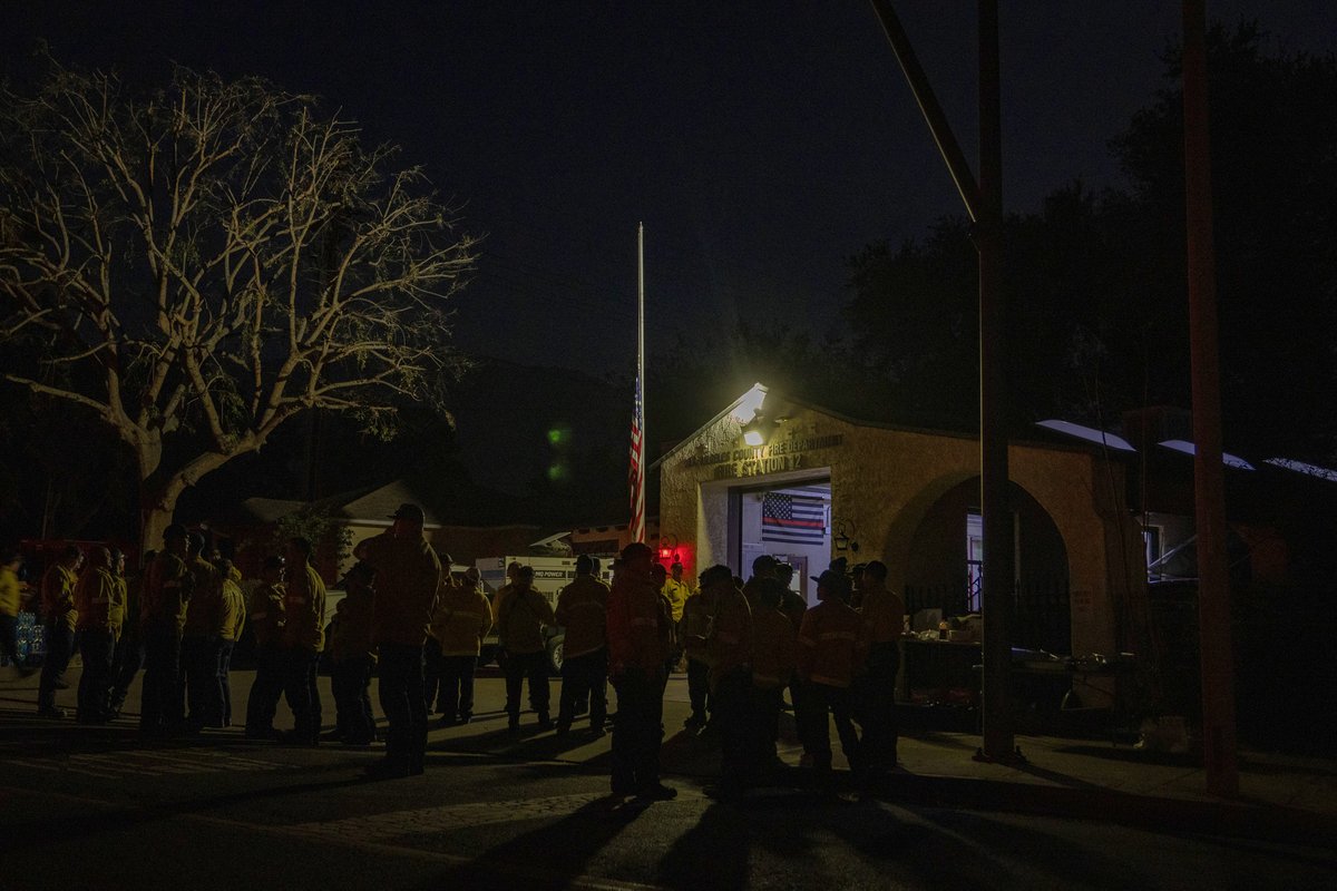 Photospice's tweet photo. The flag flies at half-mast as dozens of firefighters, from around the nation, gather for dinner at the LA County Fire Station 12 in Altadena, on Jan. 11, 2025. Sixteen people have been killed in the wildfires. 📸 by #BarbaraDavidson for @washingtonpost https://t.co/2gA2fttcnU