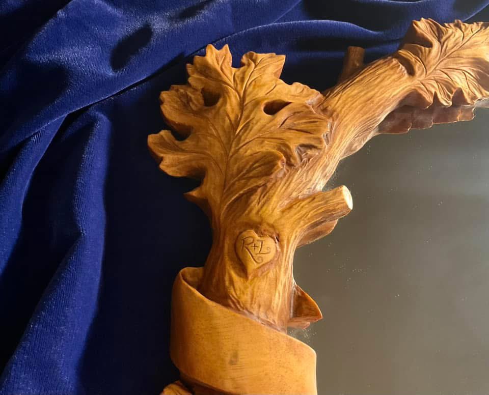 Raymond_Kinman's tweet photo. This hand carved mirror frame has a story to tell.  There’s four parts to it…

Part One - Opening Scene: 
This mirror frame was created as an original commission I carved back in the mid-90s. Recently, the client reached out to see if I could repair it…it had been badly damaged during a move and when it arrived at my studio it was in five pieces.

Sigh.

Part Two - The Restoration:
It was touch and go, but I managed to piece it back together. However, the damage was so extensive it became clear to me that I’d have to completely re-carve the entire frame. It needed it anyway….after all, I’m a better woodcarver now than I was in the 90s, so I gave it a fresh, updated life.

Part Three:  A New Chapter:
The first piece in a new signed, limited edition series of this mirror frame is on my workbench right now. I’m keeping the first one (#1 of 195) as Marisa’s Valentine’s Day gift (yes, she knows!). Hers in the lower-right photo.

Part Four:  The Plot Twist:
Check out the Valentine heart carved into the branch bark on the left side, much as young lovers might do, complete with initials.

For the original commission, the client requested the iconic phrase from Snow White without the question mark: “Who is the Fairest One of All.”

For Marisa’s mirror, I made a change.  Hers says: “The Fairest One of All.”

#SnowWhite #Disney #Woodworking