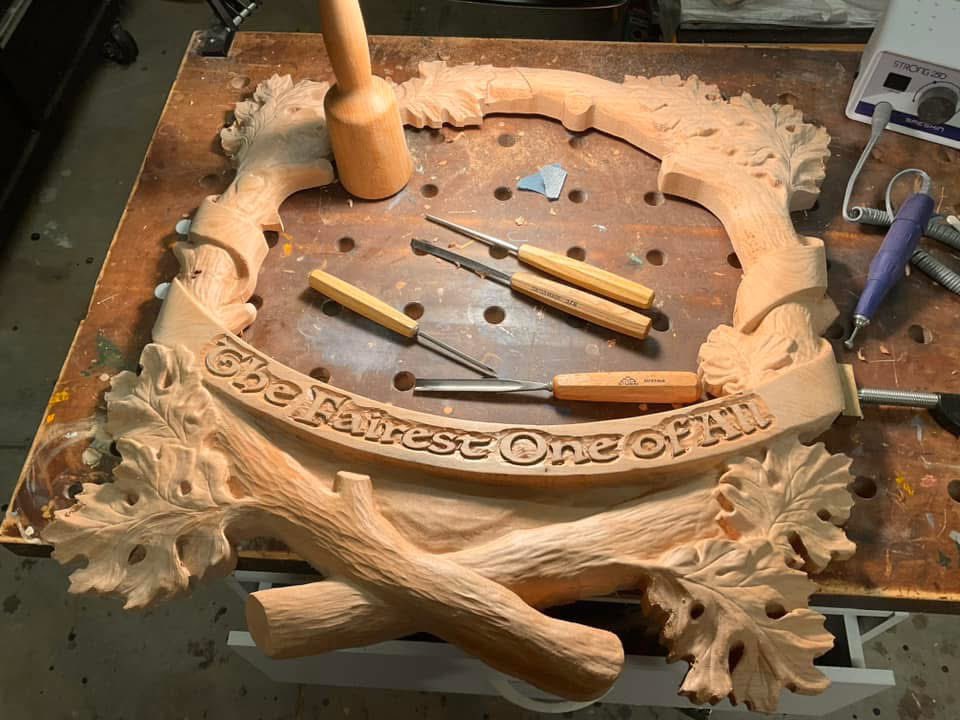 Raymond_Kinman's tweet photo. This hand carved mirror frame has a story to tell.  There’s four parts to it…

Part One - Opening Scene: 
This mirror frame was created as an original commission I carved back in the mid-90s. Recently, the client reached out to see if I could repair it…it had been badly damaged during a move and when it arrived at my studio it was in five pieces.

Sigh.

Part Two - The Restoration:
It was touch and go, but I managed to piece it back together. However, the damage was so extensive it became clear to me that I’d have to completely re-carve the entire frame. It needed it anyway….after all, I’m a better woodcarver now than I was in the 90s, so I gave it a fresh, updated life.

Part Three:  A New Chapter:
The first piece in a new signed, limited edition series of this mirror frame is on my workbench right now. I’m keeping the first one (#1 of 195) as Marisa’s Valentine’s Day gift (yes, she knows!). Hers in the lower-right photo.

Part Four:  The Plot Twist:
Check out the Valentine heart carved into the branch bark on the left side, much as young lovers might do, complete with initials.

For the original commission, the client requested the iconic phrase from Snow White without the question mark: “Who is the Fairest One of All.”

For Marisa’s mirror, I made a change.  Hers says: “The Fairest One of All.”

#SnowWhite #Disney #Woodworking