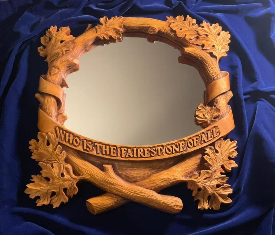 Raymond_Kinman's tweet photo. This hand carved mirror frame has a story to tell.  There’s four parts to it…

Part One - Opening Scene: 
This mirror frame was created as an original commission I carved back in the mid-90s. Recently, the client reached out to see if I could repair it…it had been badly damaged during a move and when it arrived at my studio it was in five pieces.

Sigh.

Part Two - The Restoration:
It was touch and go, but I managed to piece it back together. However, the damage was so extensive it became clear to me that I’d have to completely re-carve the entire frame. It needed it anyway….after all, I’m a better woodcarver now than I was in the 90s, so I gave it a fresh, updated life.

Part Three:  A New Chapter:
The first piece in a new signed, limited edition series of this mirror frame is on my workbench right now. I’m keeping the first one (#1 of 195) as Marisa’s Valentine’s Day gift (yes, she knows!). Hers in the lower-right photo.

Part Four:  The Plot Twist:
Check out the Valentine heart carved into the branch bark on the left side, much as young lovers might do, complete with initials.

For the original commission, the client requested the iconic phrase from Snow White without the question mark: “Who is the Fairest One of All.”

For Marisa’s mirror, I made a change.  Hers says: “The Fairest One of All.”

#SnowWhite #Disney #Woodworking