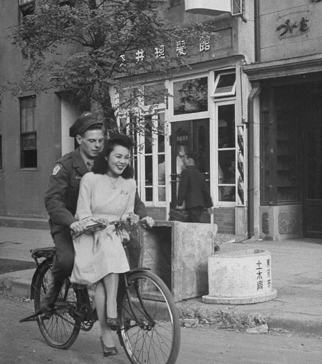 US soldier giving his Japanese girlfriend a bicycle ride, Japan, 1946.