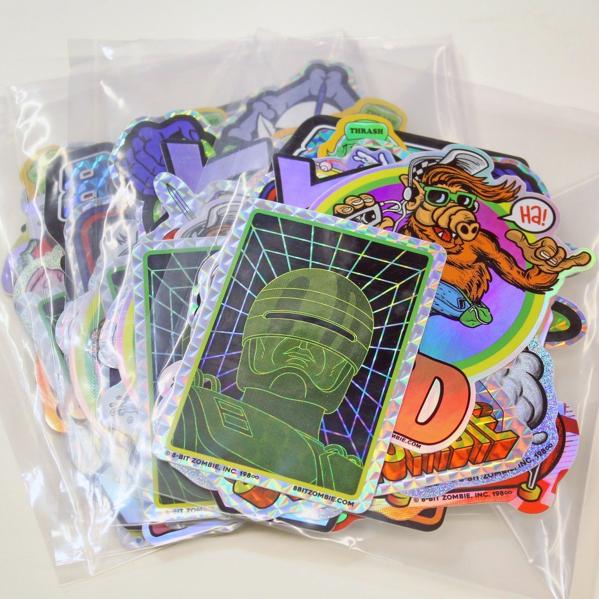 Apparently today is “National Sticker Day”!? Well, if there was ever a fake holiday 8BZ was ready for, it’s this one! To celebrate I’ve added some of our RAD GRAB BAGS back to the store! Pick up 16 of our shiniest stickers at a discount:
✨8BITZOMBIE.COM✨