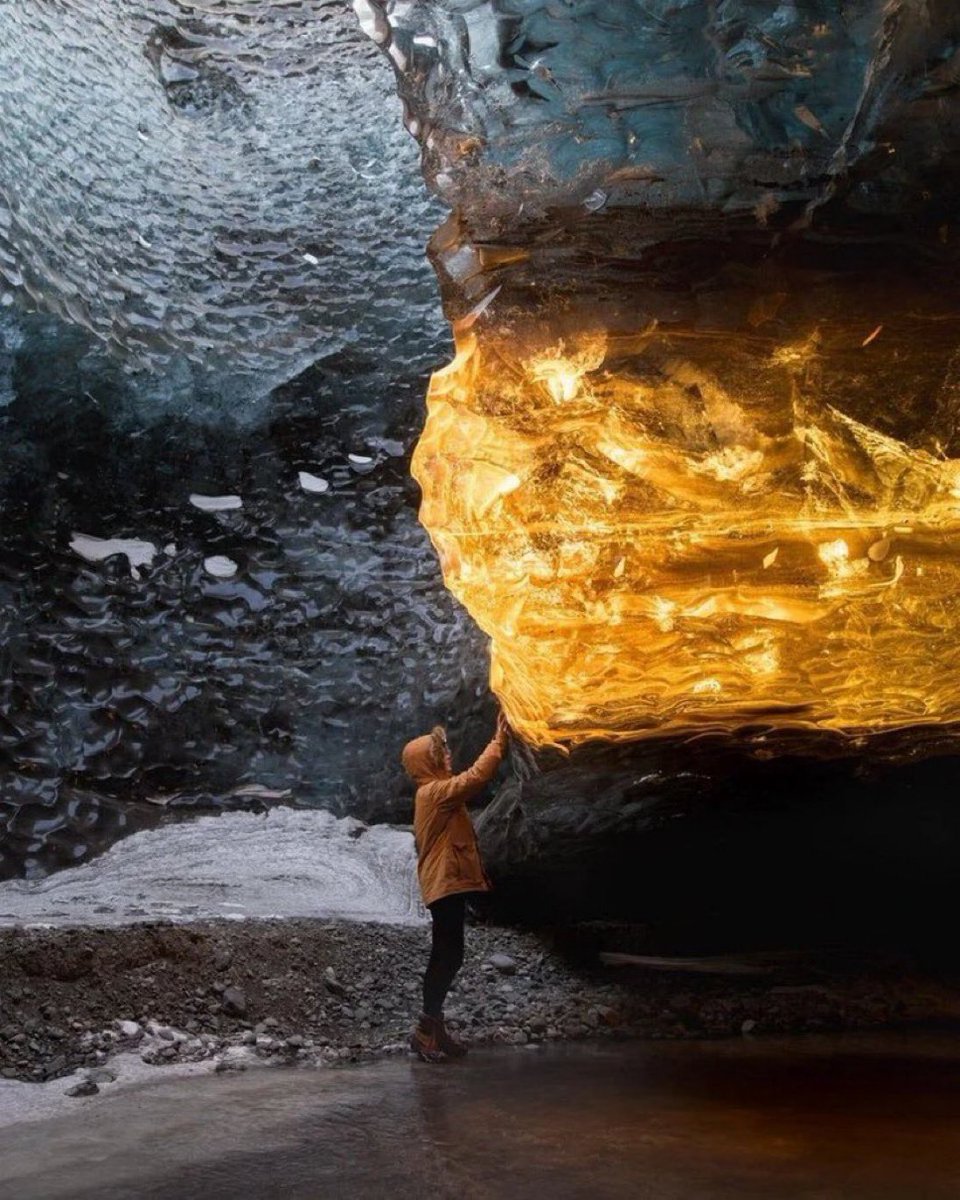 21. Travel photographer Sarah Bethea captured this stunning photograph in Iceland.

Where the golden rays of the setting sun entered an ice cave, dyeing a section of the cave's ice an amber color.