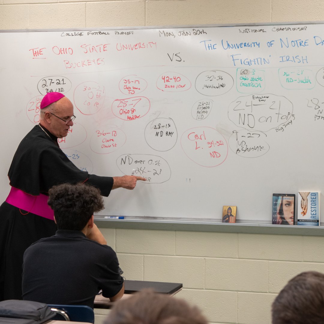 Bishop Rhoades visited Theology classrooms this afternoon.  Mr. Lushis' theology students had written predictions on the whiteboard for the winner and final score of the upcoming Notre Dame vs Ohio State game. Bishop Rhoades added his prediction as well. 

#LuersSpirit