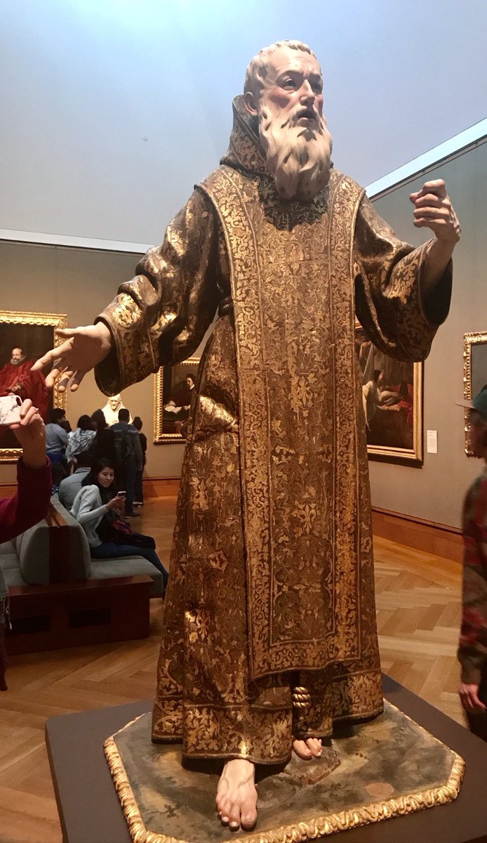 Raymond_Kinman's tweet photo. We saw this astonishing carved wood statue of St. Gines de la Jara at the Getty Museum, and it completely took my breath away.  The details were so stunning, so lifelike….the museum information plaque didn’t include many details, so I wanted to know more about the artist who created this incredible carving.  

As it turns out, this statue was carved in 1692 by….

Wait for it….

A woman?

It’s true.  This incredible piece was carved by Luisa Roldán, or La Roldana, a 17th-century Spanish sculptor who broke barriers as the first female court sculptor for the kings of Spain.  In the 17th century, women weren’t accepted as professional artists because society expected them to stick to domestic roles like running a household and raising children. 

Training opportunities were scarce; women were often barred from workshops, guilds, and art academies, and they couldn’t study crucial subjects like anatomy, because it was considered “inappropriate” for a woman. 

Sculpture, in particular, was considered too physical for women, and most patrons preferred commissioning men, assuming women lacked the skill and/or professionalism. 

La Roldana defied all of that. She learned carving in her father’s workshop, honed her craft, and ultimately became the first female court sculptor to the kings of Spain.

Despite her obvious genius, Roldán lived much of her life in poverty, even as the court sculptor.  She struggled financially despite her immense talent.  This was partly because, even at the highest levels, artists of her time were often underpaid or faced delays in receiving payment for commissions. Additionally, as a woman, she faced extra hurdles in gaining consistent and lucrative work, as patrons consistently favored  male artists.

Although she held a prestigious position, the court often failed to pay her regularly or adequately. Combined with the lack of a strong support system and her limited ability to advocate for herself in a male-dominated field, these factors left her in a state of near poverty throughout much of her life.

She was a master of polychrome sculpture, carving figures out of wood and bringing them to life with layers of intricate paintwork. Using a technique called encarnación, she created the illusion of translucent, living skin, even painting delicate blue veins beneath the surface. To heighten the realism, the statue also features glass eyes, which catch the light, making the figure feel almost alive.

What’s really striking is her use of exaggeration. Hands and feet are really difficult to carve.  The slightly oversized hands and feet of St. Gines amplify the emotional intensity and presence of this piece, right down to the tiniest details such as the toenail fungus.  Notice how the knuckles are a tiny bit larger than in real life.

It appears to me that at one time this dude may have been holding something in his left hand but I couldn’t find any information about that.
#BaroqueArt #Sculpture #ArtHistory #WomenInArt #GettyMuseum #LaRoldana #SpanishArt #WoodSculpture #PolychromeSculpture #FemaleArtists